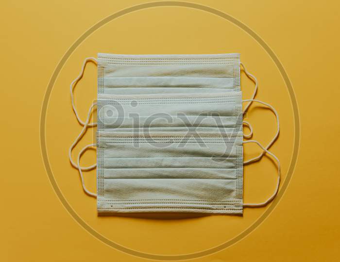 Bunch Of Medical Masks Over A Yellow Background