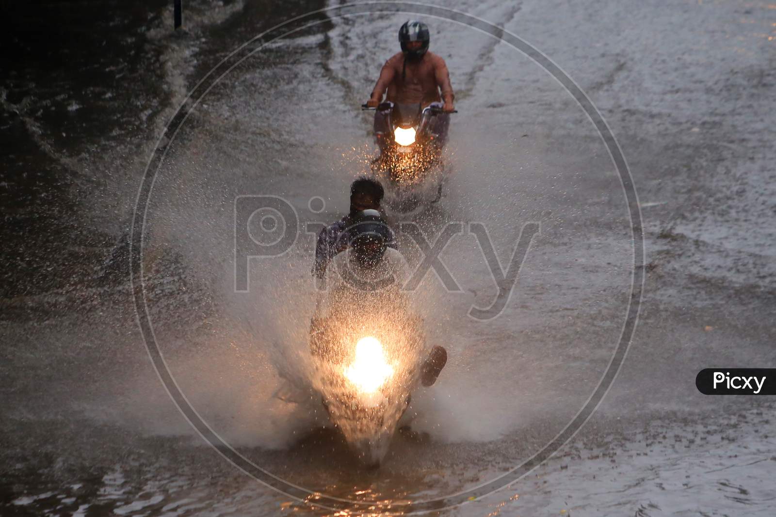 People drive through a flooded road during heavy rains in Ajmer, On August 1, 2020.