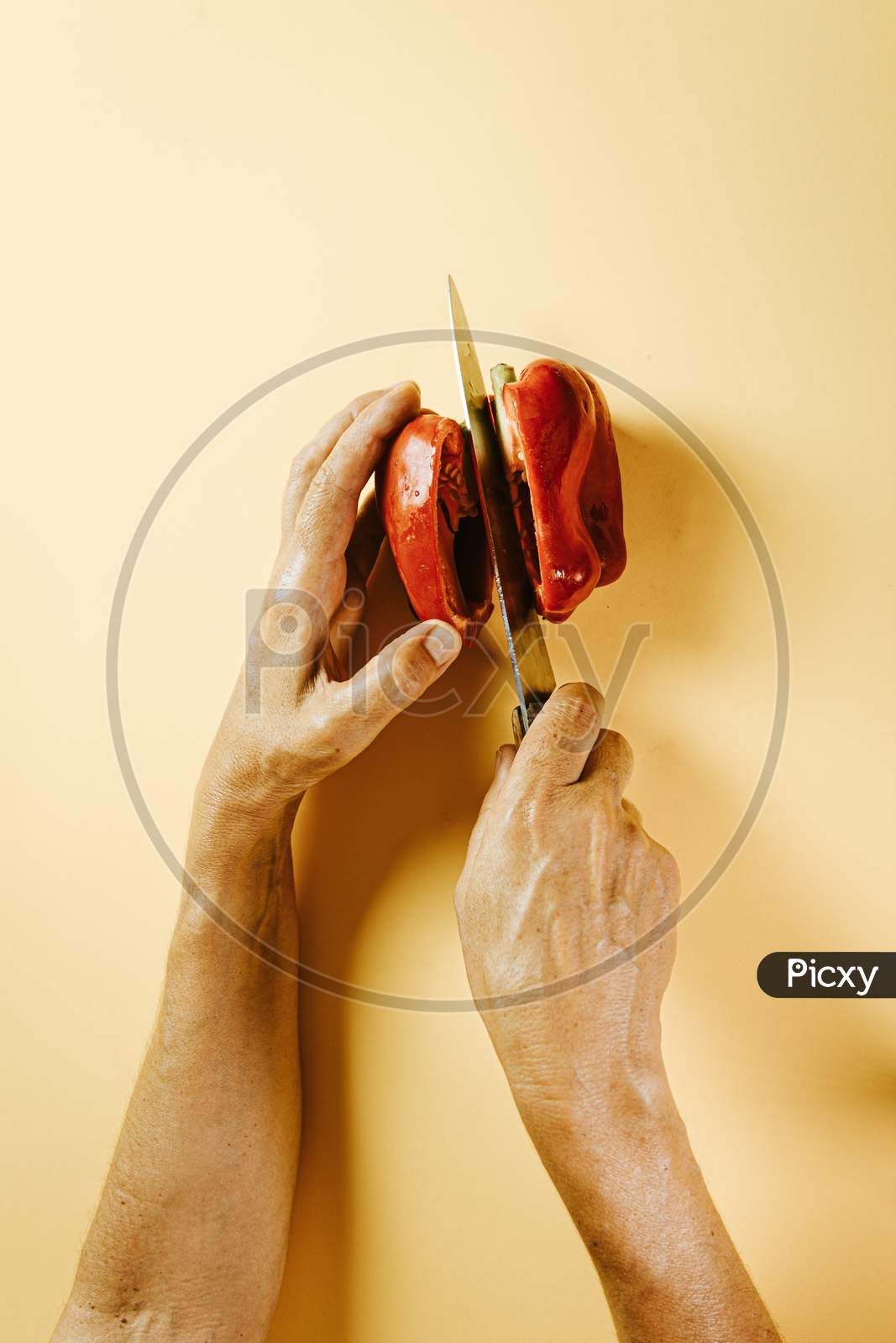 Old Woman Hands Cutting A Pepper