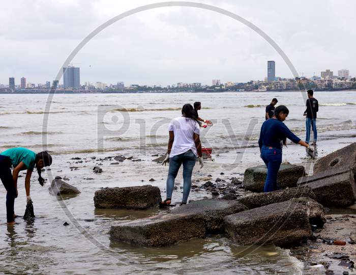 Volunteers helping to clean up the Mumbai dadar beach during rain