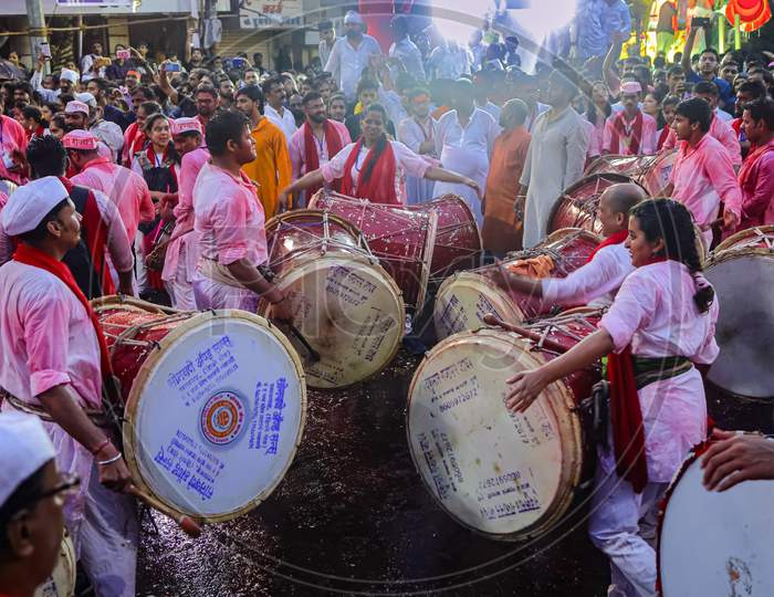 A group of devotees beating drums during the festival of an Indian God Ganesh Puja