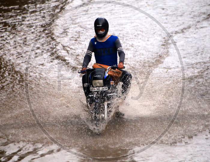 A man drives through a flooded road during heavy rains in Ajmer, On August 1, 2020.