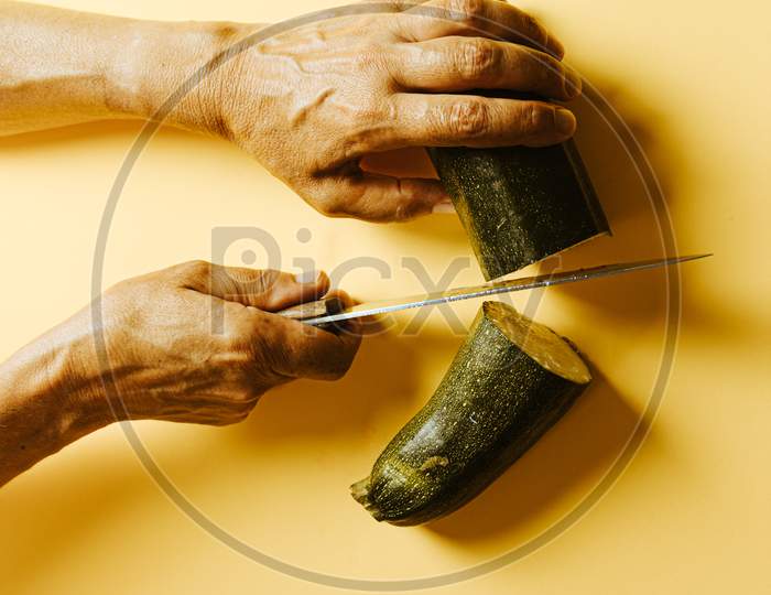 Old Woman Hands Cutting A Zucchini