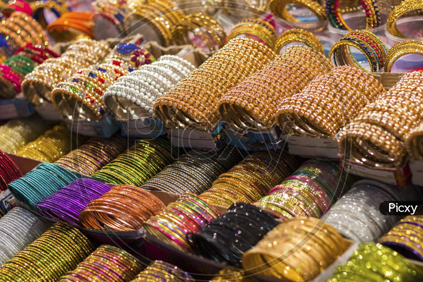 Multi-Colored Indian Glass/Metal Bangles Arranged On The Shelf For Sale