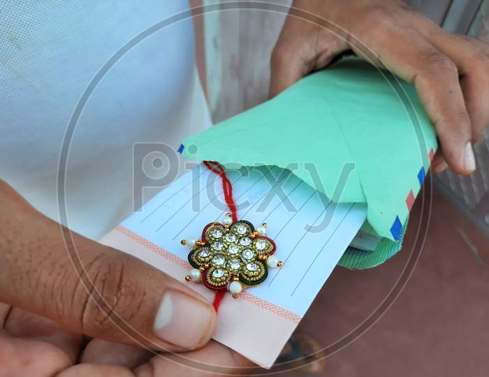 Male Opening Rakhee Envelope With Message On Raksha Bandhan