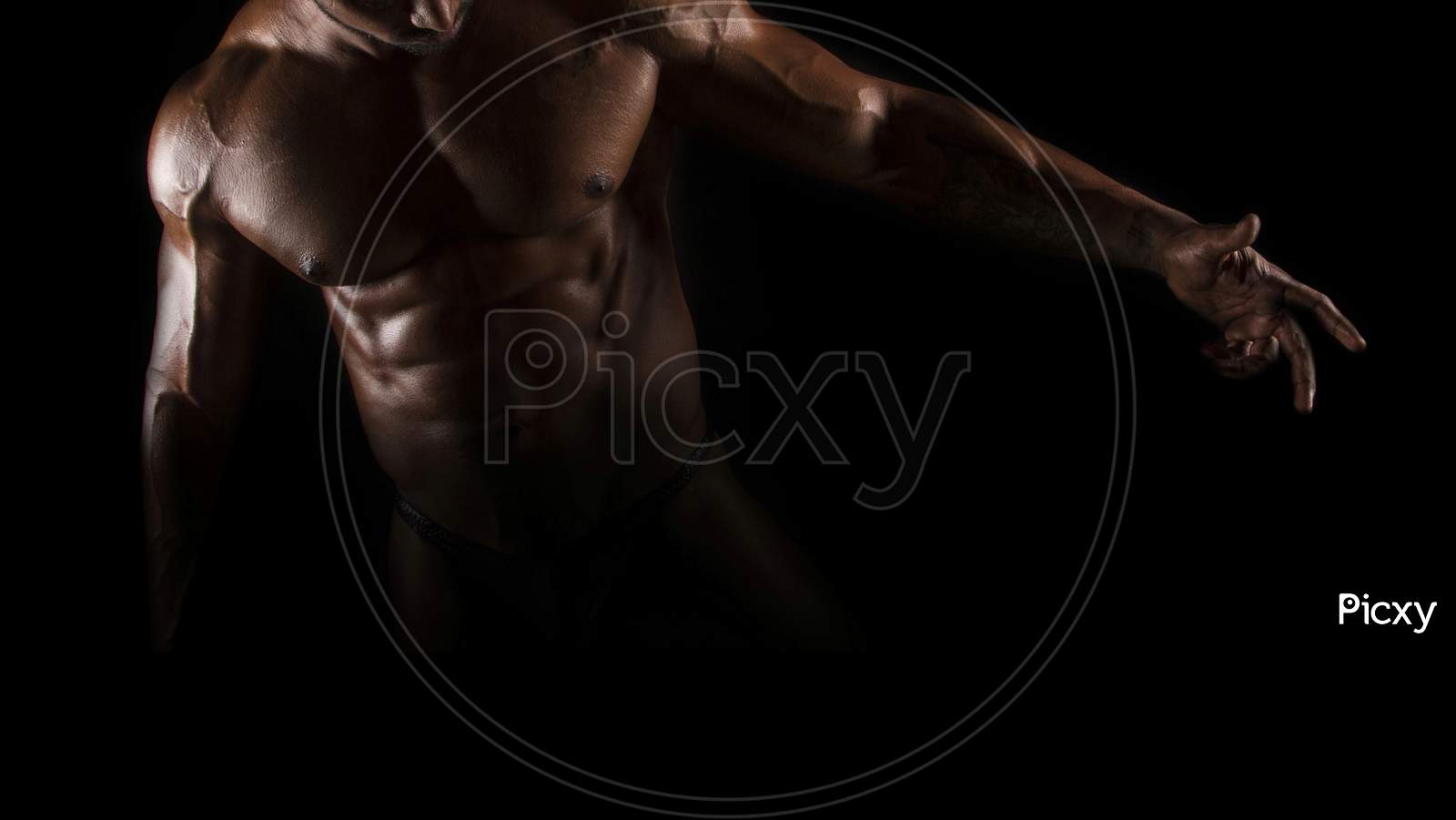 Silhouette of young athlete bodybuilder man on black