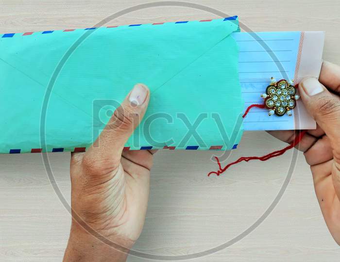Male Opening Rakhee Envelope With Message On Raksha Bandhan