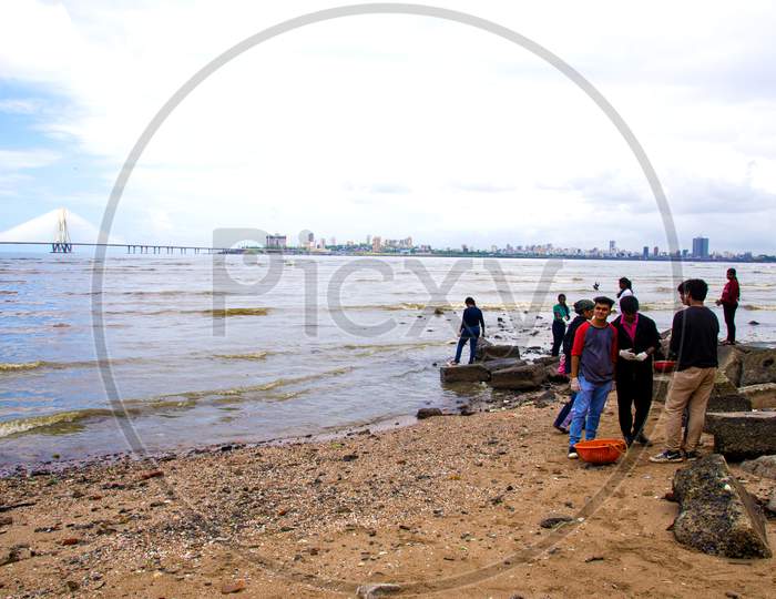 Volunteers helping to clean up the Mumbai dadar beach during rain