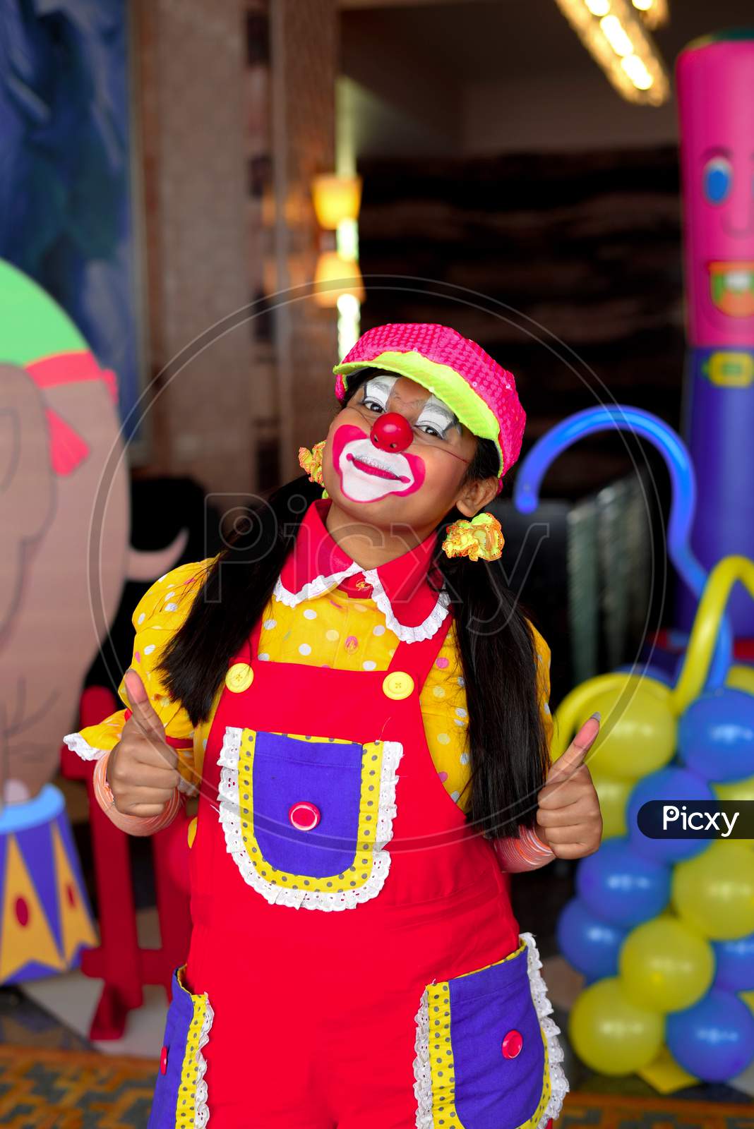 A female clown facing a camera and smiling pose