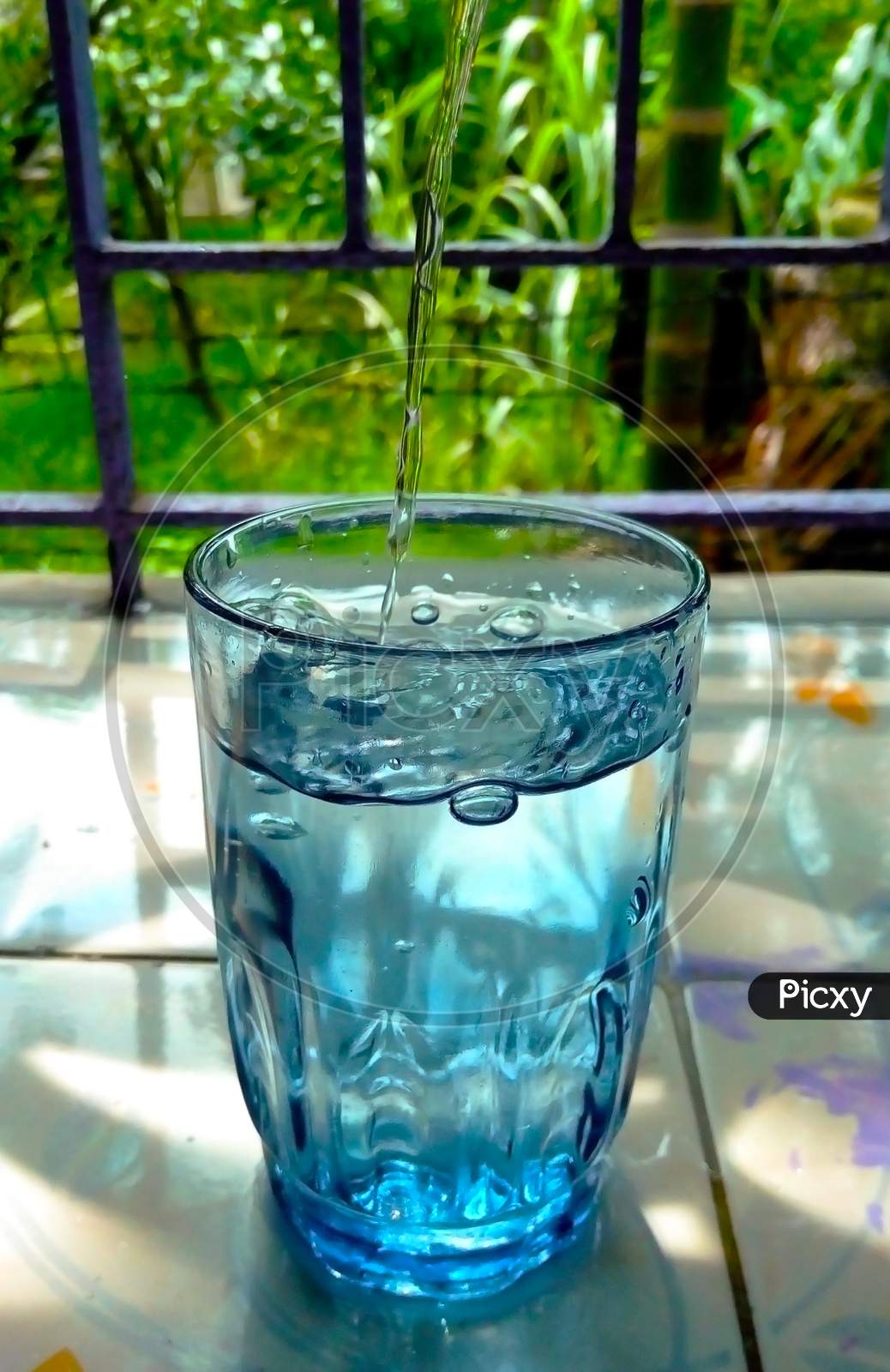 The Glass Is Being Filled By Drinking Water