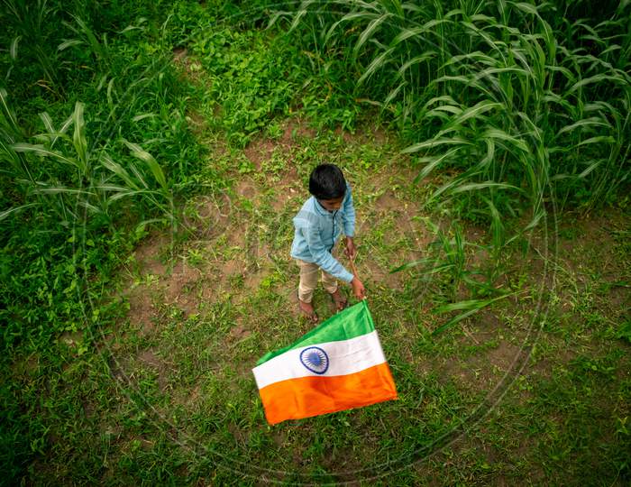 A boy holds indian flag or tricolour flag to celebrate independence day on 15 august 2020