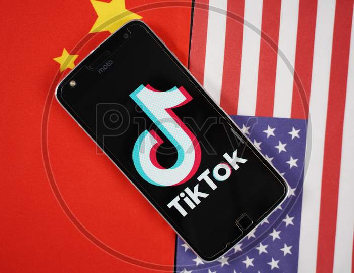 Maski, India 04, August 2020 - Tiktok App Logo On Smartphone Screen And Placed On China And United States Flags - The App Is In Centre Of Us - China Trade Tensions And Security Concerns.