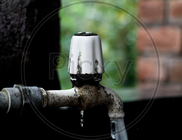 Water Flowing From An Old Plastic Water Tap