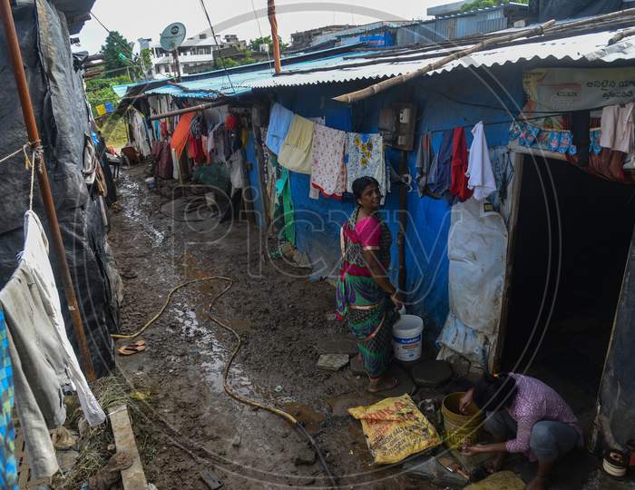 People clean up the mud that accumulated in their home caused by the flash floods in warangal, August 18, 2020.