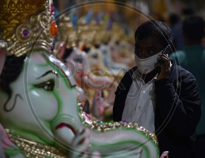 People buy Idols of Hindu deity Lord Ganesh with facemasks amid tensions of rising Coronavirus cases ahead of Ganesh Chaturthi/ Vinayaka Chavithi festival in Hyderabad, Telangana on August 21, 2020.