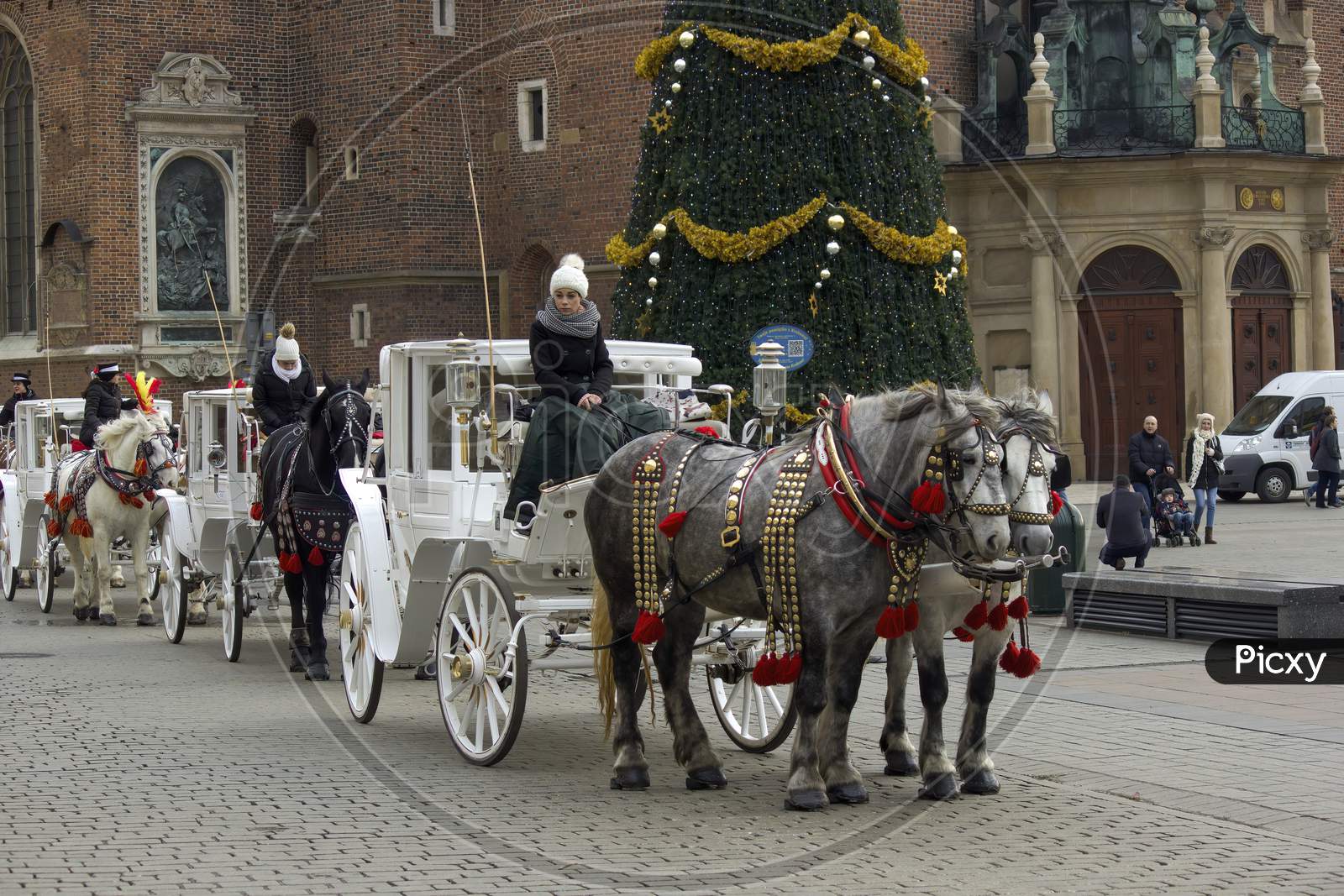 Krakow, Poland - December 23, 2014: Queue Of Horse Ride Carriage For Tourists During Christmas Eve Holidays In Winter At City Center Main Square Before X-Mas Tree