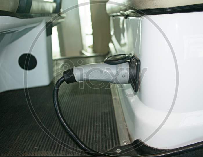 Electric Car Is Charging Using A Wired Power Plug