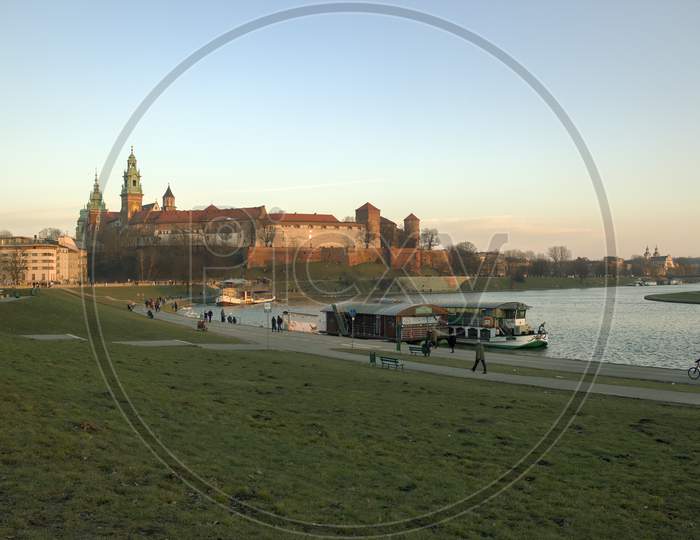 Krakow, Poland - February 21, 2015: Wide Angle View Of Wawel Castle By Vistula River And Restaurant Within Docked Ship