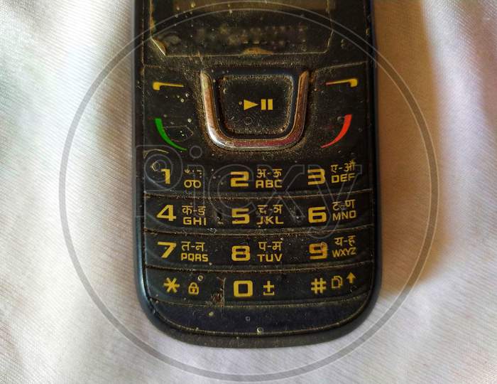 Dirty keypad of old mobile phone, with numbers and alphabets