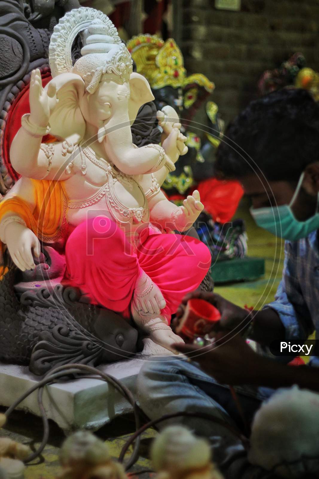 Man Coloring Idol Of Lord Ganesha