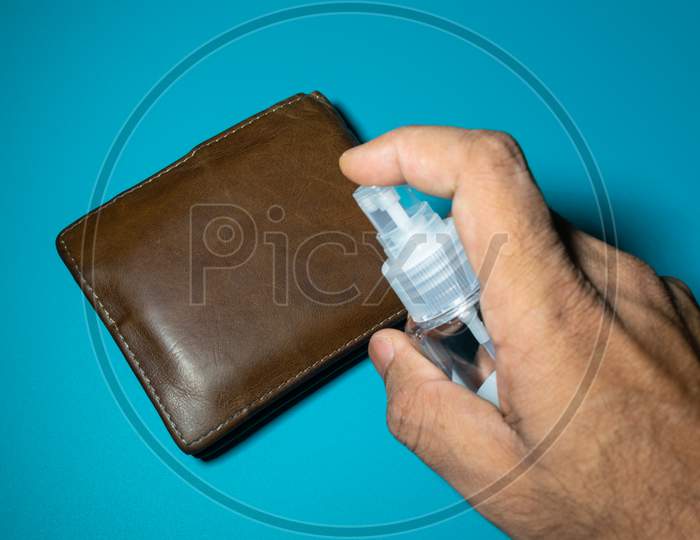 Cleaning Wallet With Sanitizer To Prevent From Corona Virus, Covid 19