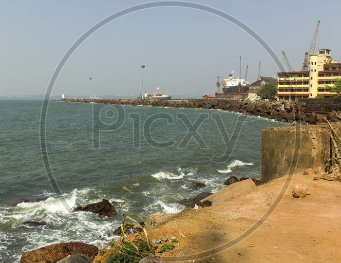 Goa, India - February 28, 2013: Wide Angle Of Vasco Port With Ship Docked By The Rocky Beach