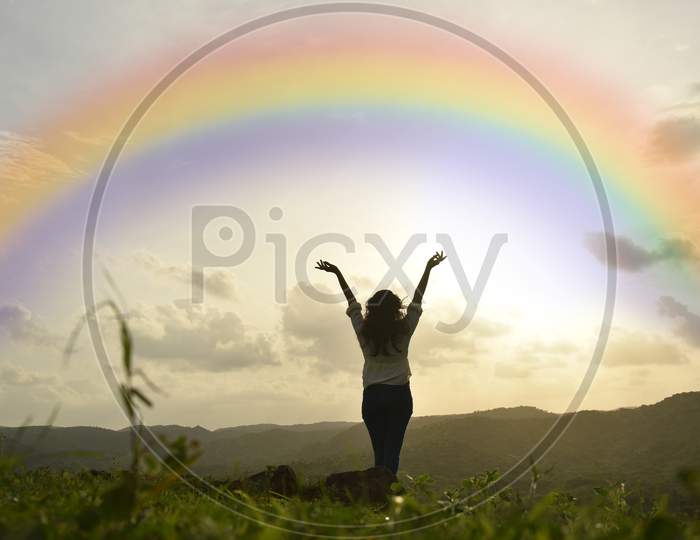 Traveler Young Girl Enjoying And Watching Rainbow With Sun Set .
