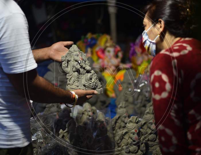 People buy Idols of Hindu deity Lord Ganesh with facemasks amid tensions of rising Coronavirus cases ahead of Ganesh Chaturthi/ Vinayaka Chavithi festival in Hyderabad, Telangana on August 21, 2020.