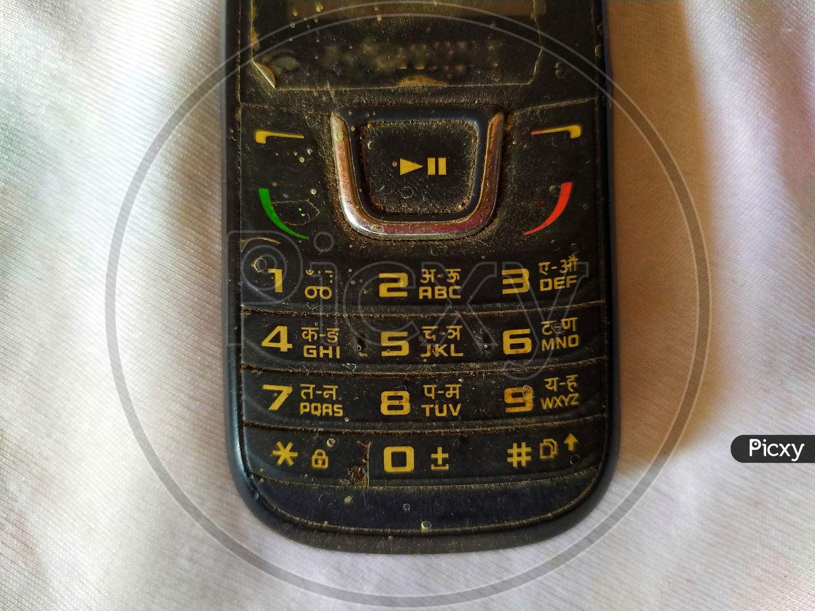 Dirty keypad of old mobile phone, with numbers and alphabets