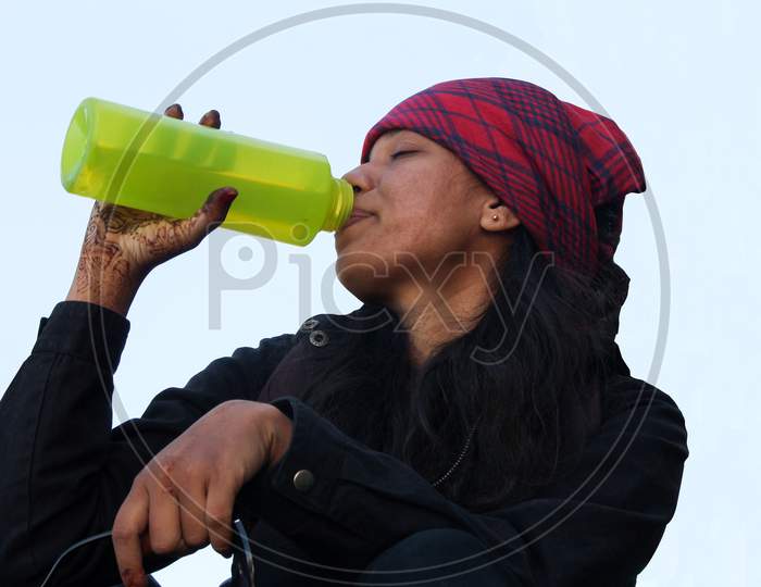 Young Woman Drinking Water Using Green Bottle