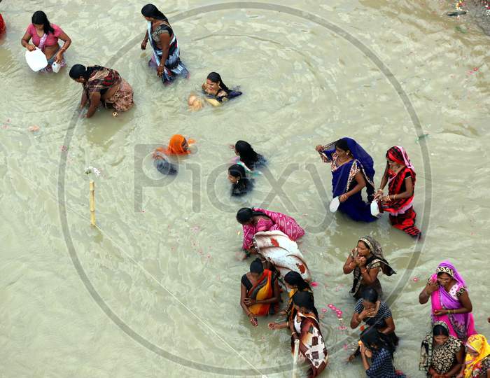 Hindu women devotees take holy dip in the Ganga river on the occasion of Teej festival for the long life of their husband in Prayagraj, August 21, 2020.