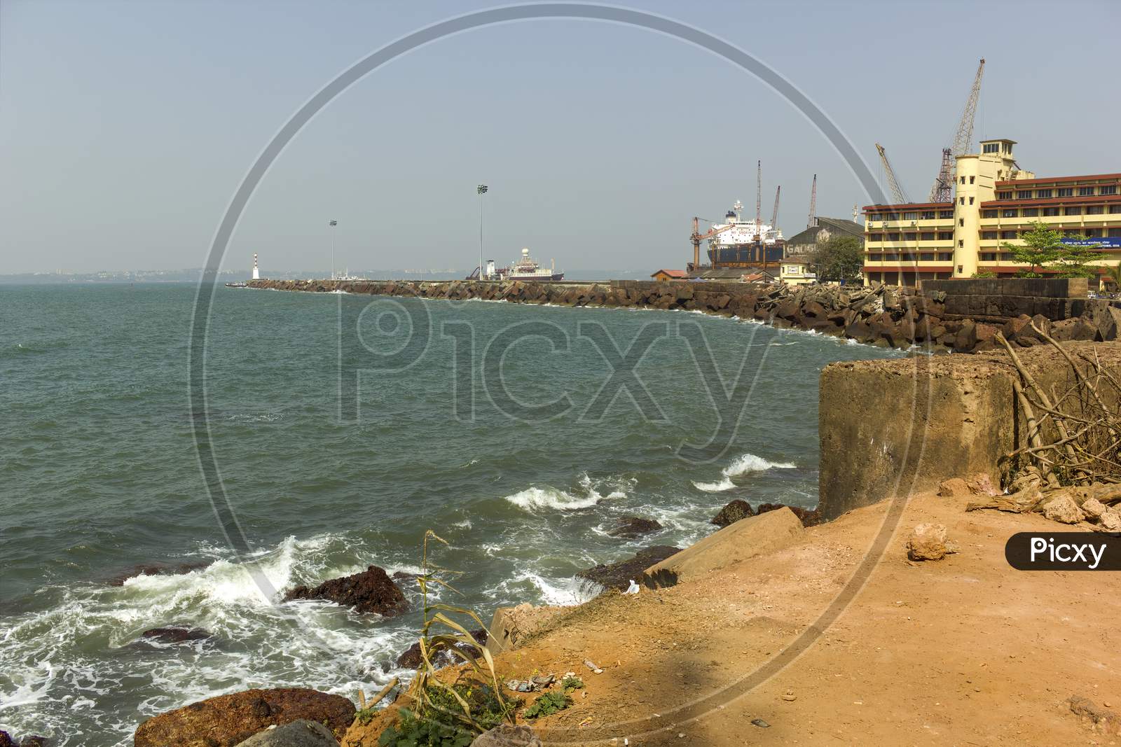 Goa, India - February 28, 2013: Wide Angle Of Vasco Port With Ship Docked By The Rocky Beach