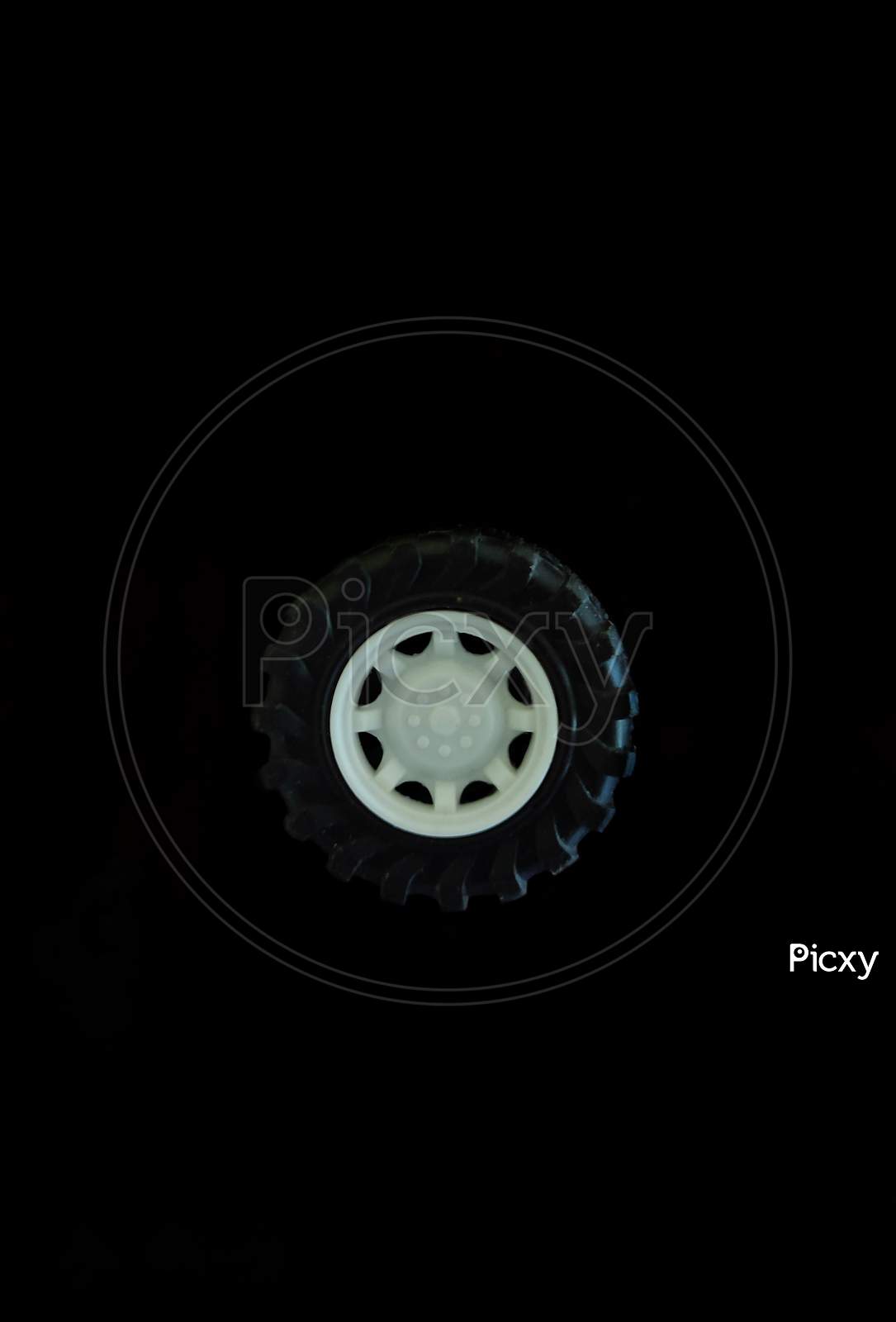 A Tyre With White Color Wheel With Black Background.