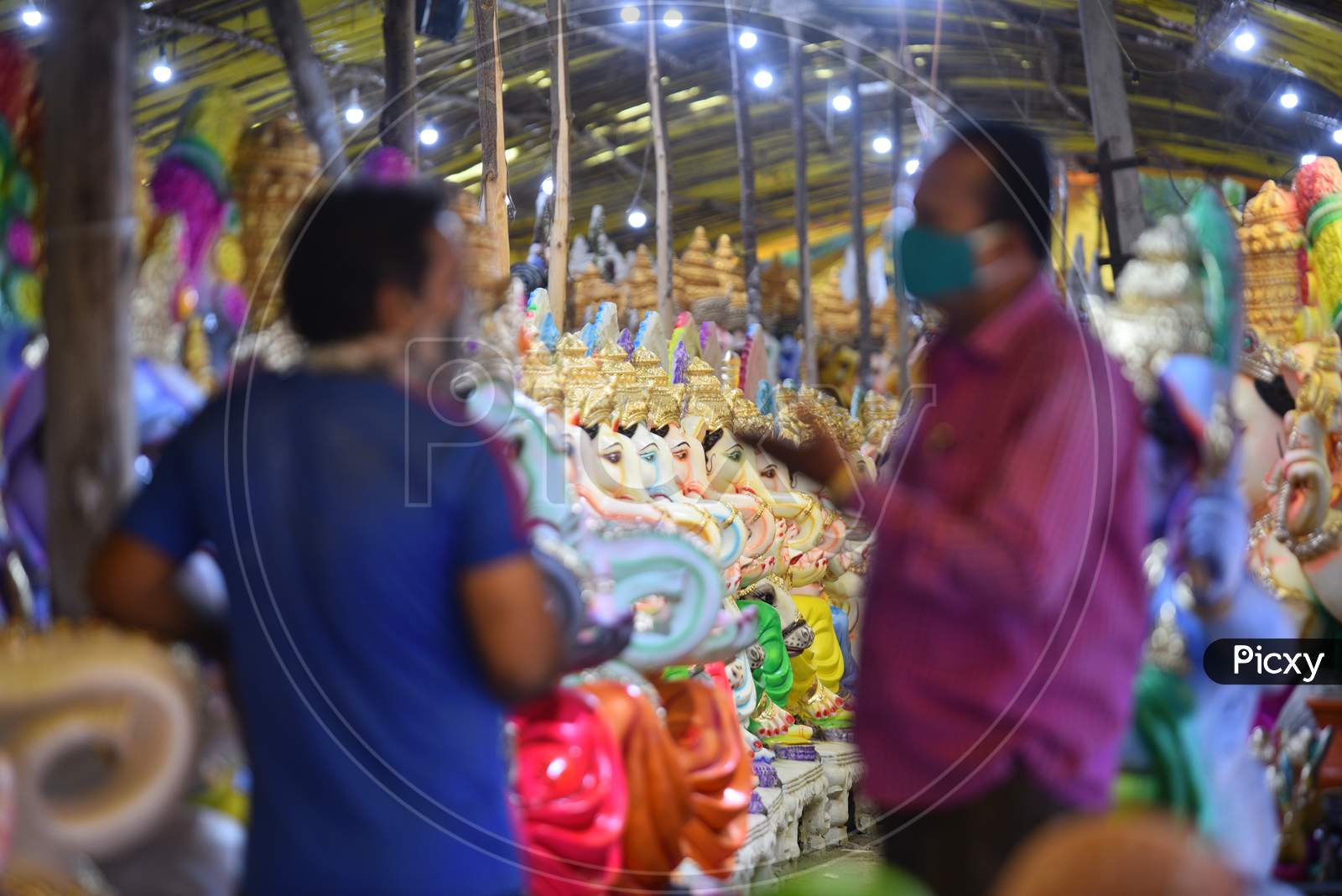 People wearing facemasks buy idols of Hindu deity , Lord Ganesh ahead of Ganesh Chaturthi in Hyderabad, August 21,2020.