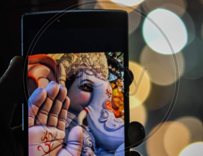 Ganesh Idols displayed in mobile screen with bokeh background