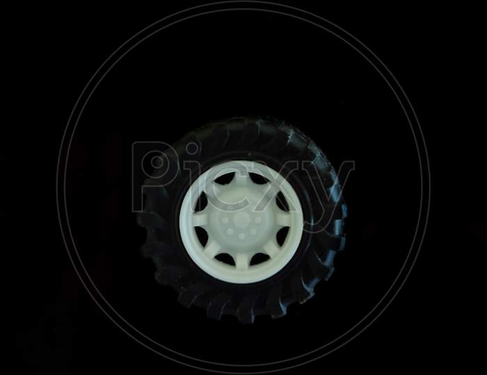 A Tyre With White Color Wheel With Black Background.