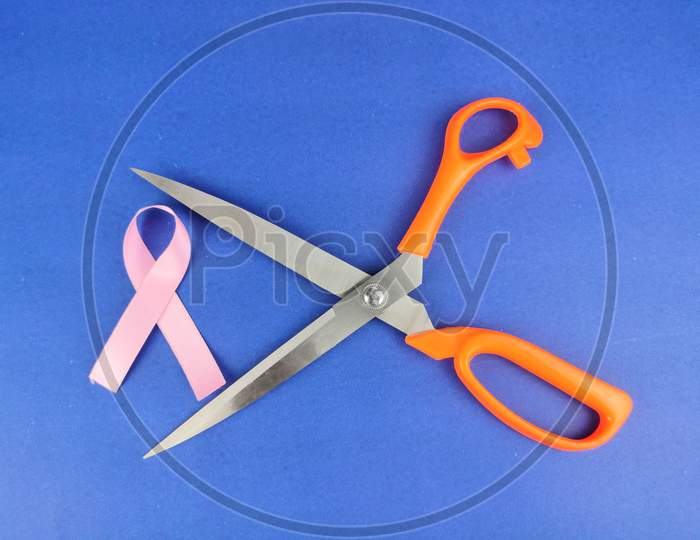 Pink ribbon with Scissors , fight with breast cancer Concept,  Selective Focus.