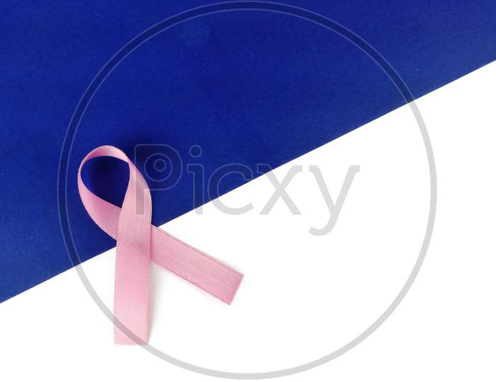Pink ribbon on blue White background, cancer awareness poster with space for text