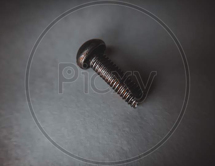 macro photography of a small screw with dark theme.