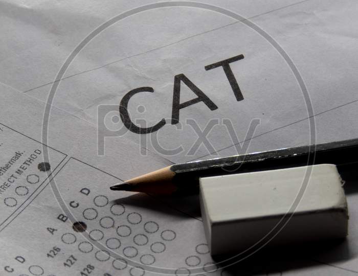Concept Of Cat Exam Or Common Admission Test With Pencil Eraser And Paper.