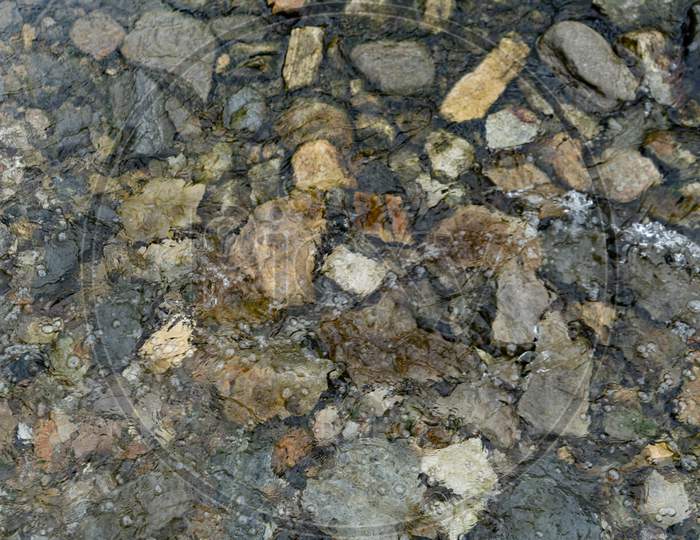 Abstract Design Formed By Various Numbers Of Pebbles Scattered In The River, Background Texture Of Pebbles.