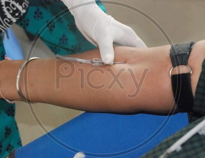 Blood Donation. Female Doctor Tacking Blood On Man Hand.
