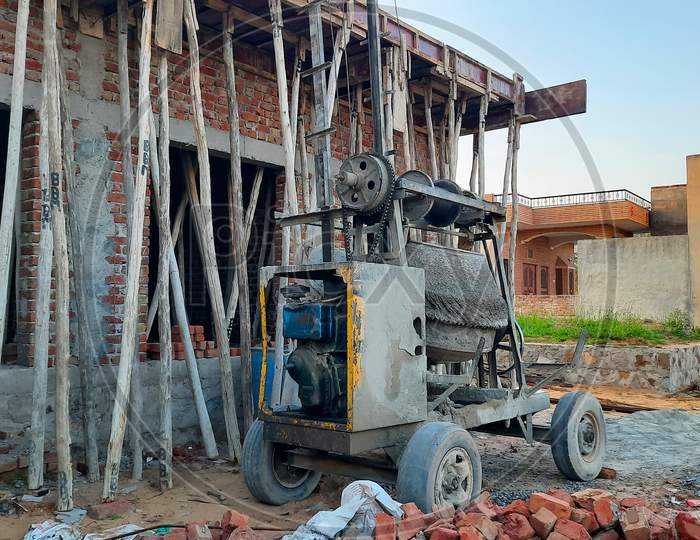 Wooden Poles And Cement Mixture Loader Under Rcc Roof On Construction Site In India