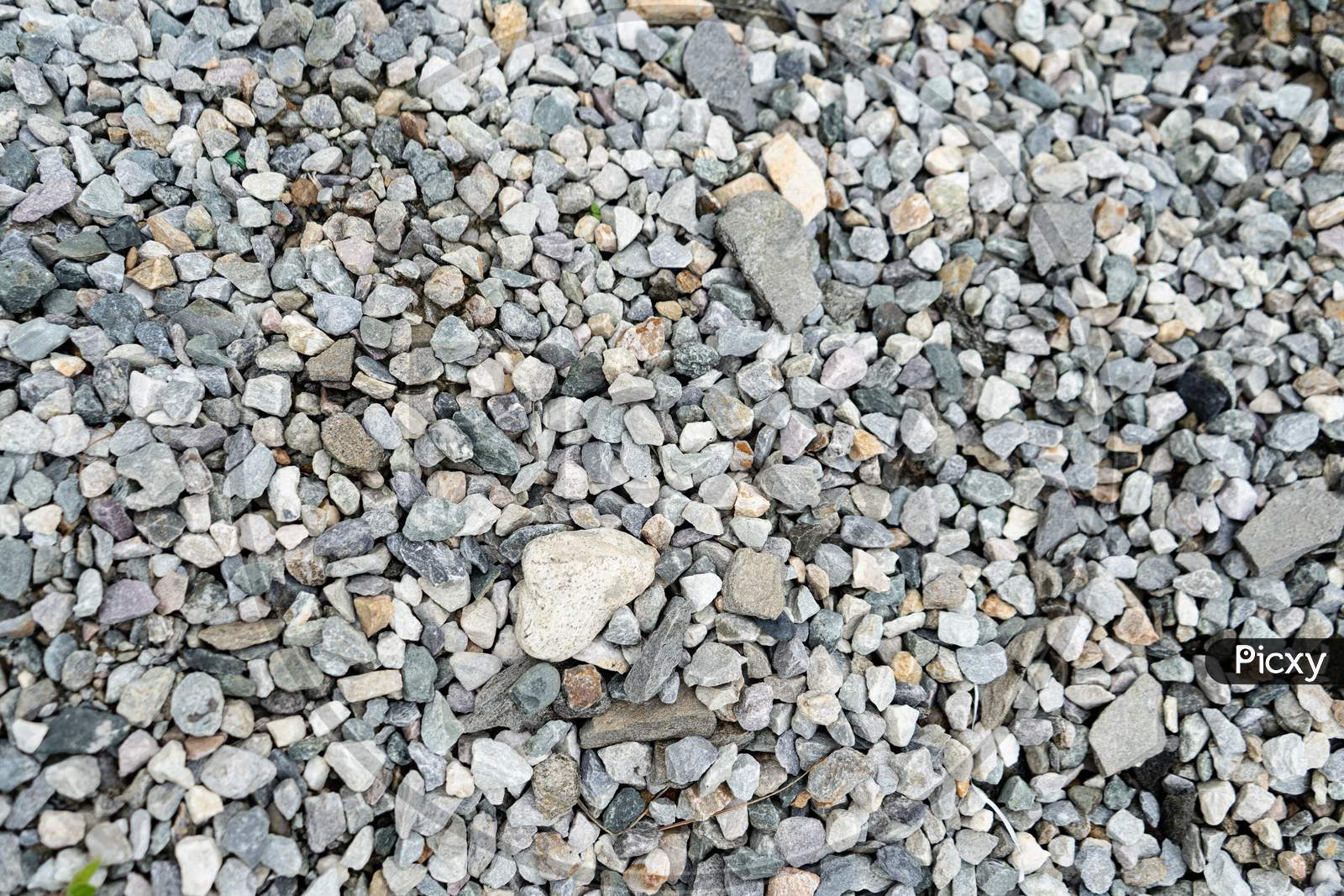 Abstract Design Formed By Various Numbers Of Pebbles Scattered In The Lawn, Background Texture Of Pebbles.