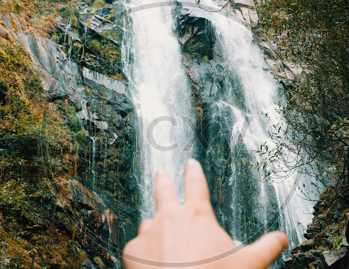Out Of Focus Hand Reaching To A Majestic Waterfall