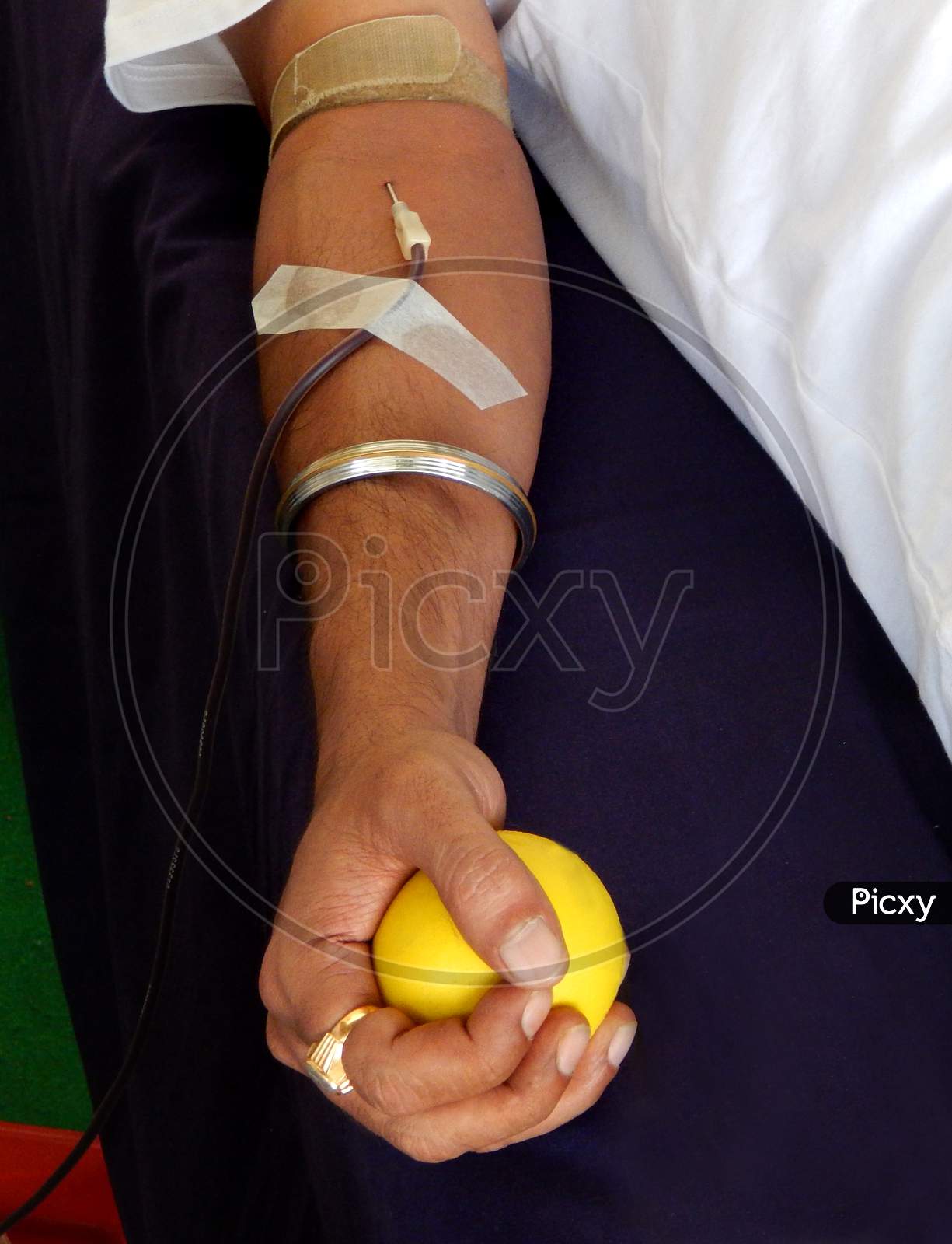 Close-up view of hand of Indian man, holding a yellow ball,donating blood
