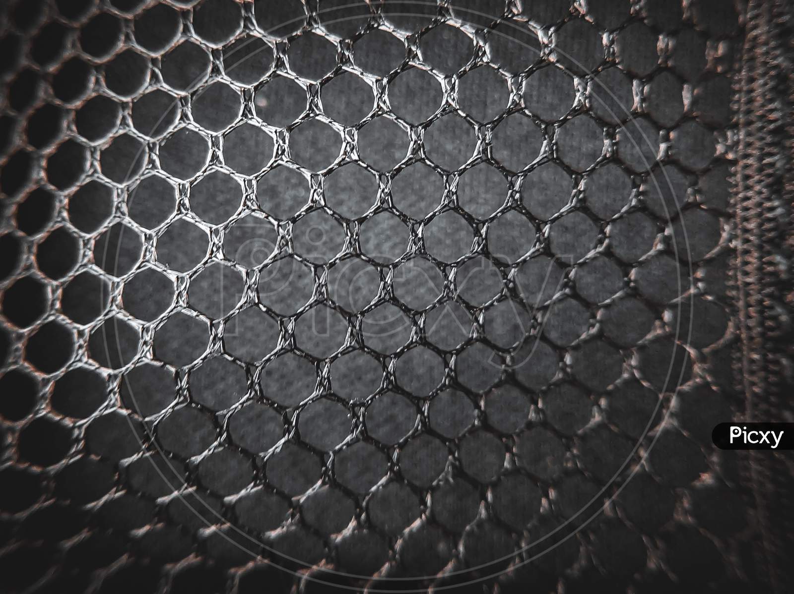A photo of hexagonal shape net giving texture and surface to the image for creating a wallpaper.