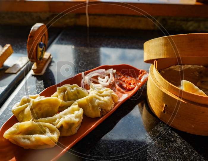 Traditional Dumpling Momos Food From Nepal Served With Tomato Chutney Over Moody Background. Selective Focus