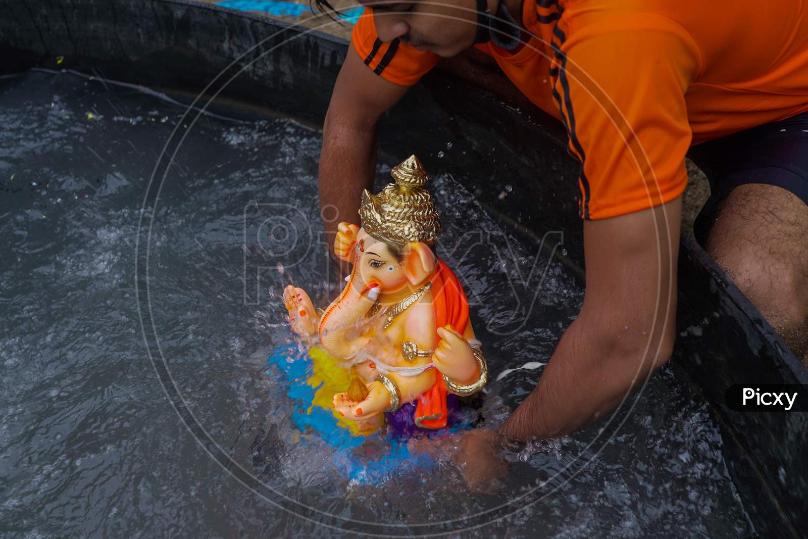 Ganesh idol immersion in covid 19 pandemic restrictions. Ganpati Visarjan In Man Made pond People With Mask
