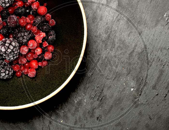 Red Berries And Black Berries On A Black Plate And Slate Background. Flat Lay. Organic Gastronomic Food